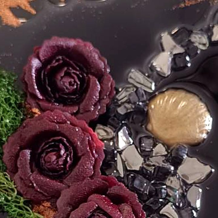 Close-up of the deep red resin roses and green moss in River of Hope