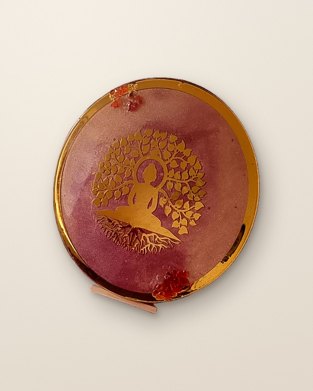Round rose-pink resin plaque with a gold Buddha beneath a bodhi tree