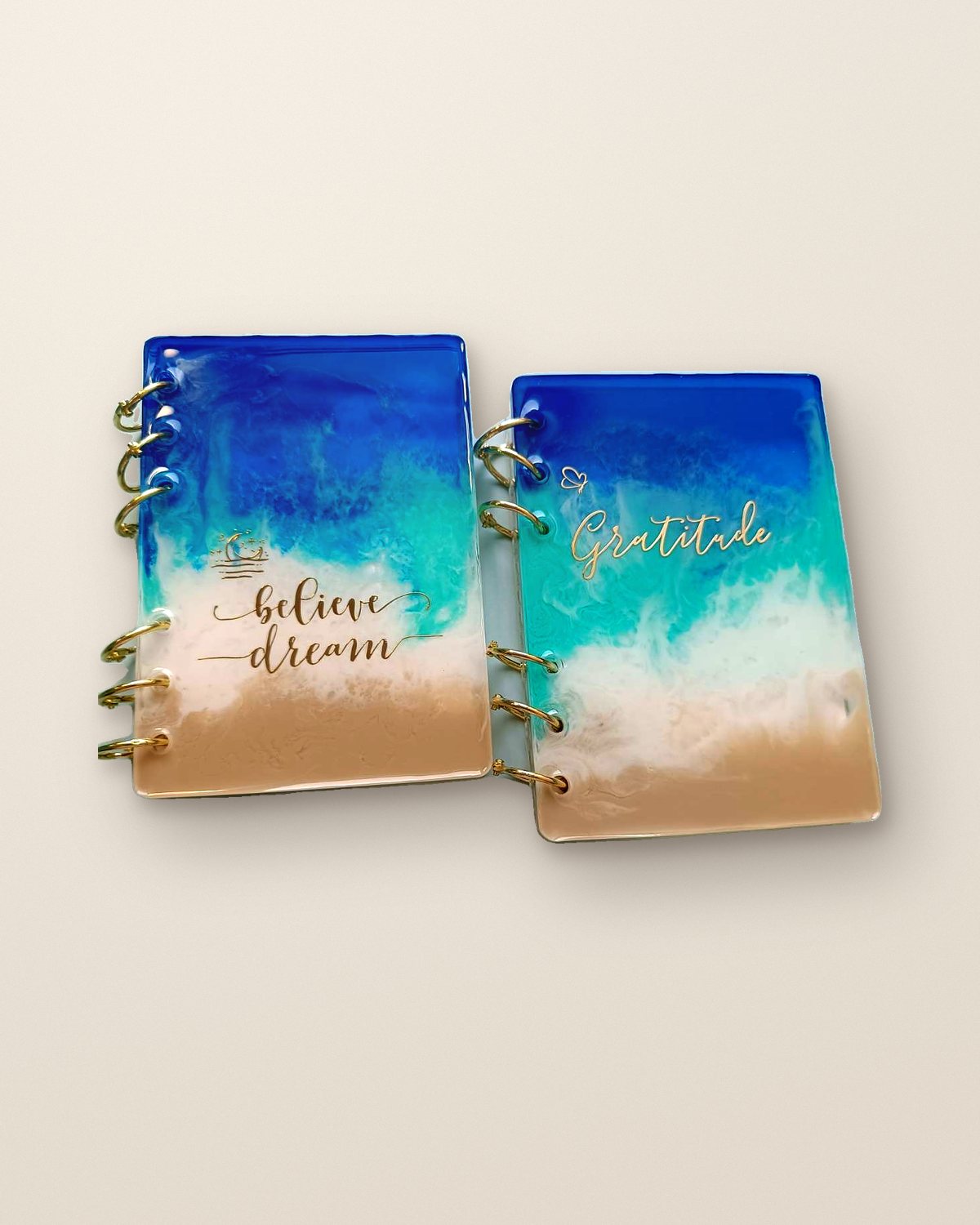 Two personalised resin diaries in ocean blues with gold lettering