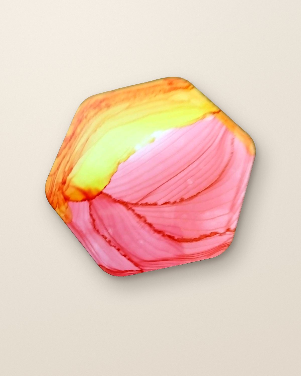 Hexagonal resin coaster in coral pink and sunset yellow