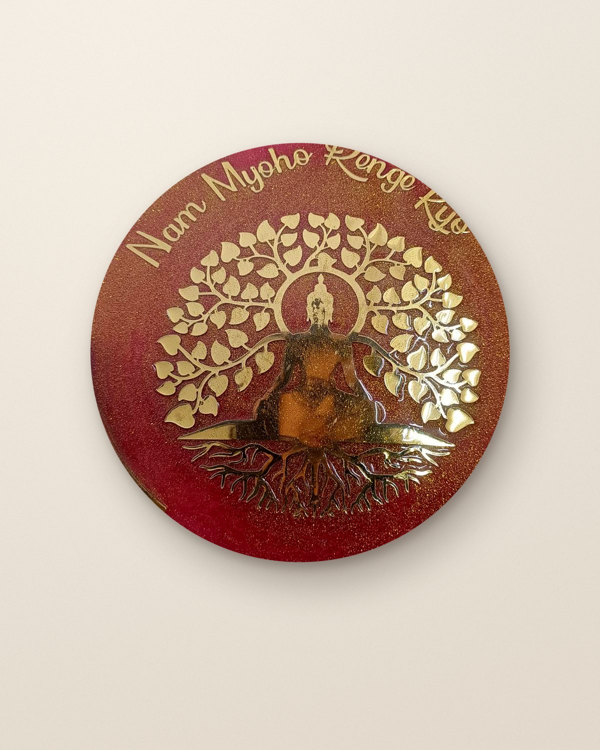 Nam Myoho Renge Kyo resin wall art in red with a gold Buddha and bodhi tree, hung on a plaster wall